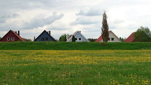 View of field against cloudy sky