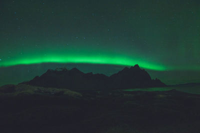 Scenic view of mountains with aurora against sky at night