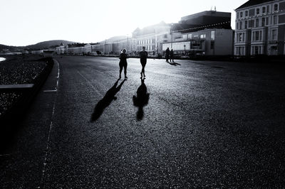 People walking on street in city against clear sky