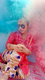 Full length portrait of woman sitting on floorby powder paint