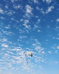 Low angle view of person paragliding against sky