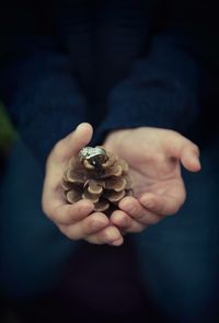 Close-up of hand holding object over white background