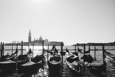 Boats moored in canal against clear sky