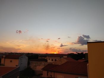 Houses against sky during sunset