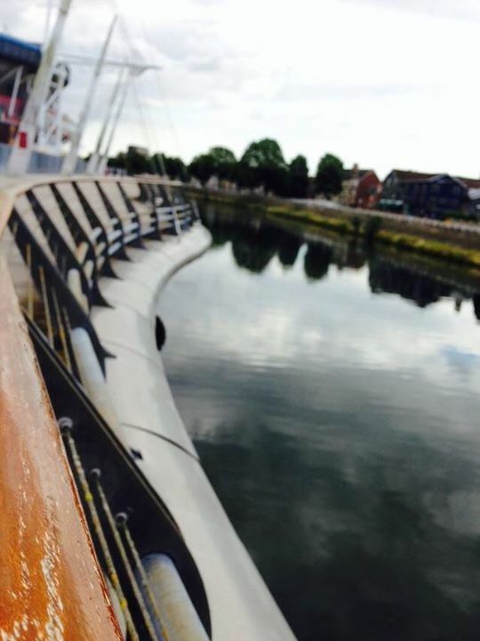 REFLECTION OF BRIDGE AND CLOUDS ON RIVER