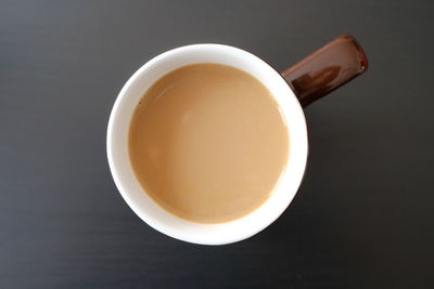 Directly above shot of tea cup on table against black background