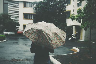 Rear view of woman walking in rain