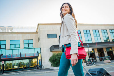 Portrait of young woman standing on street