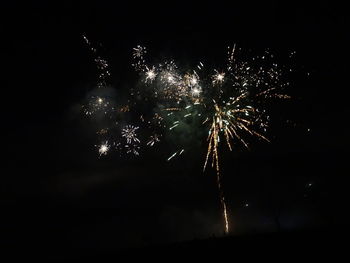 Low angle view of firework display at night