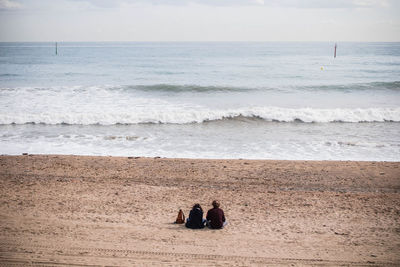 People standing on beach against sky