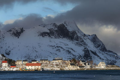 Scenic view of sea by building against sky during winter