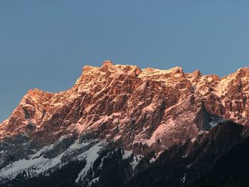 Low angle view of snowcapped mountains against clear sky