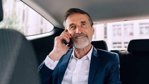 Businessman talking over mobile phone in car