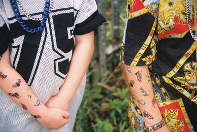 Midsection of women with tattoo on hands