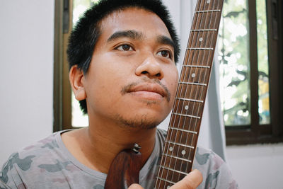 Portrait of young man playing guitar