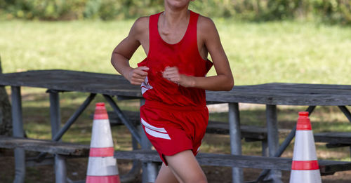 Close up of a cross country runner passing a picnic table while racing in sunken meadow state park.