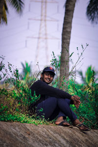 Portrait of man sitting by tree