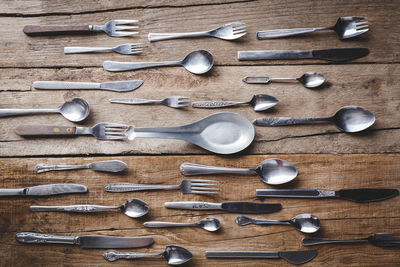 Directly above shot of eating utensils arranged on wooden table