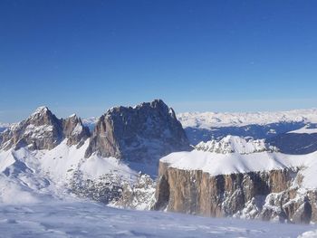 Scenic view of snowcapped mountains against clear blue sky