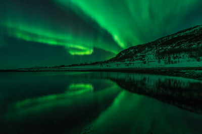 Scenic view of lake against sky at night