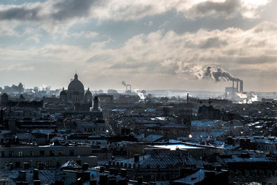 View of cityscape against cloudy sky