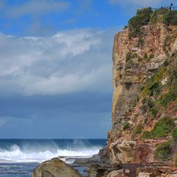 Rock formations on beach against sky