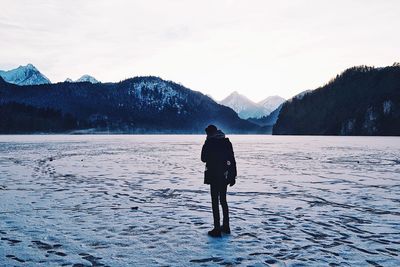 Full length of man on frozen lake against sky