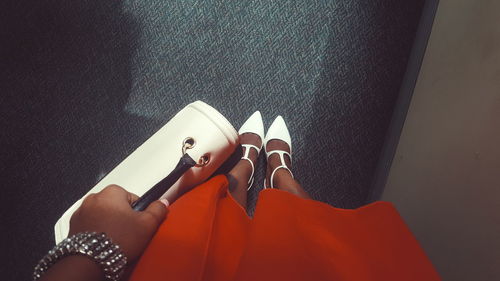 Low section of woman wearing shoes standing in corridor