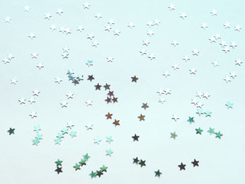 Holiday background with silver star confetti on mint background. christmas and new year.