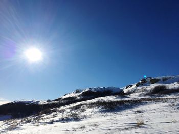 Scenic view of snowcapped mountains against clear blue sky