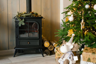 Classic cast iron fireplace with wood and christmas tree