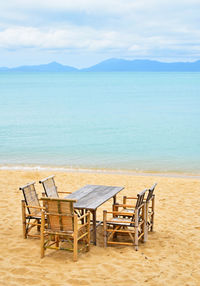 Empty table and chairs on beach