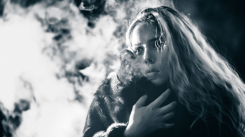 Close-up of young woman smoking outdoors