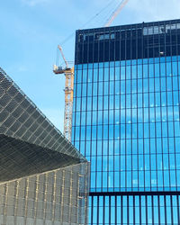 Low angle view of modern building against blue sky