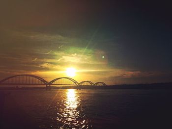 Bridge over river at sunset