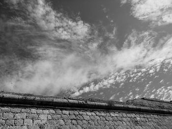 High section of stone wall against clouds