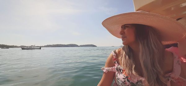 Woman wearing hat against sea against sky