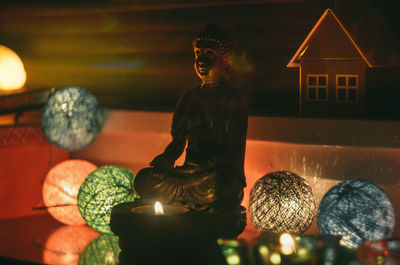 Statue against illuminated building