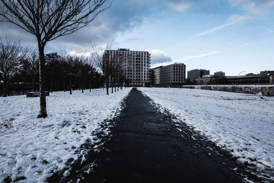 Snow covered city buildings against sky