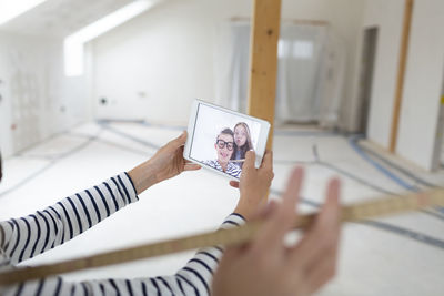 Cropped hand of girl taking selfie at construction site