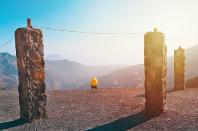 Rear view of person on mountain against sky