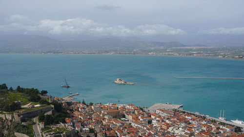 High angle view of townscape by sea against sky