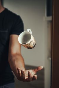 Midsection of man holding coffee cup