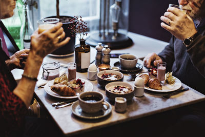 Midsection of senior couple having breakfast at table in hotel