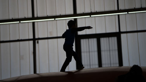 Side view of silhouette man standing against window