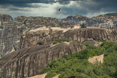 Scenic view of rocks against cloudy sky