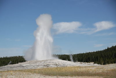 View of waterfall on landscape against sky