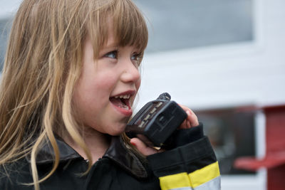 Close-up portrait of a smiling girl holding ice cream