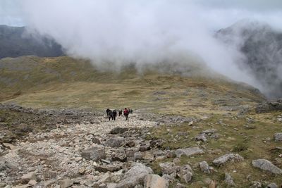 Group of people on rocky mountain with low clouds