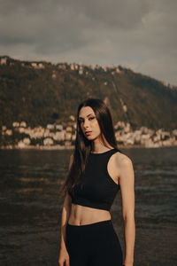 Portrait of young woman standing at beach